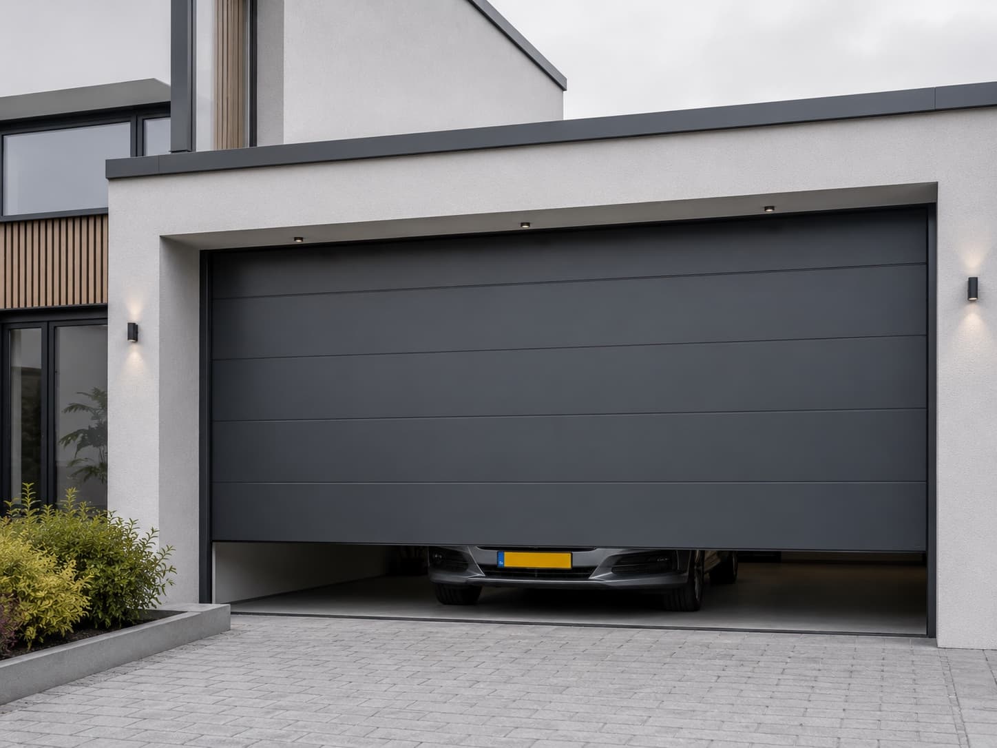Porte de garage sectionnelle anthracite sur maison contemporaine