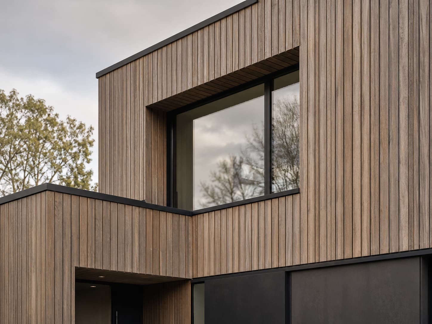 Bardage vertical en mélèze sur façade de maison contemporaine